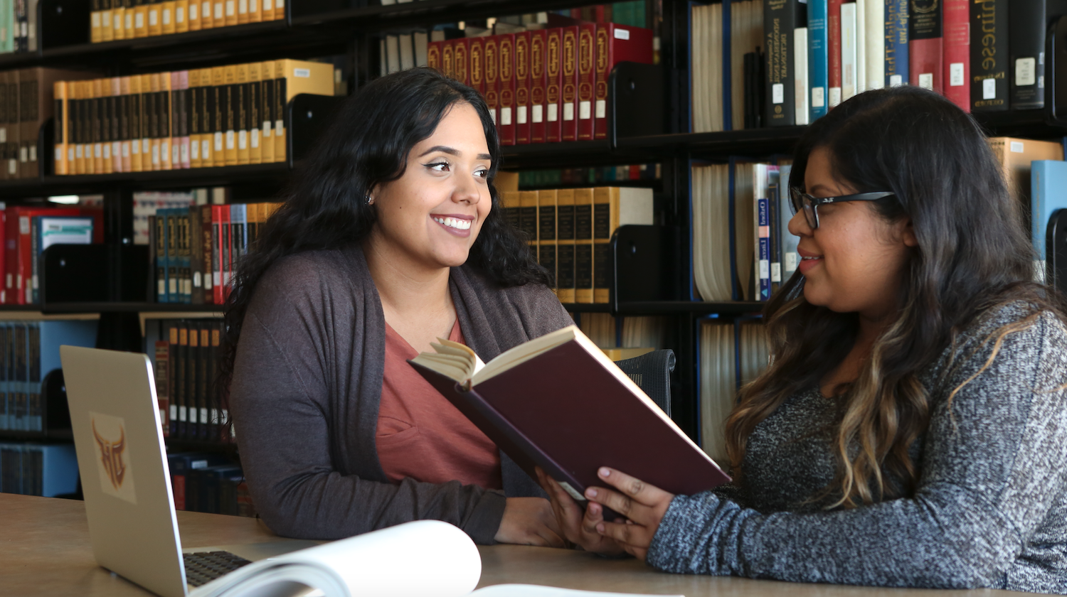 Two students with studying materials